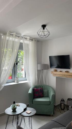a living room with a green couch and a window at Nina’s Garden in Loutraki