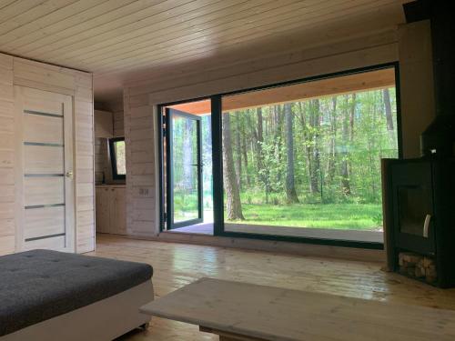 1 dormitorio con ventana grande en un bosque en Saules Krasti en Saulkrasti