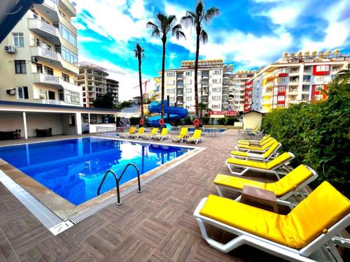 uma piscina com espreguiçadeiras e um hotel em Best Alanya Hotel em Alanya