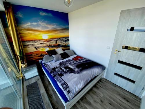 - une chambre avec un lit orné d'une peinture murale dans l'établissement Widok na Morze Porta Mare - Apartament 326, à Dziwnówek