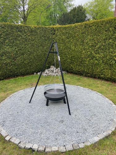 een schommel zittend op een cirkel van grind bij Ferienhaus mit großem Garten in Oldenburg