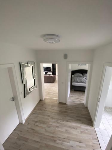 un corridoio con pareti bianche e pavimenti in legno e una camera da letto di Ferienhaus mit großem Garten a Oldenburg
