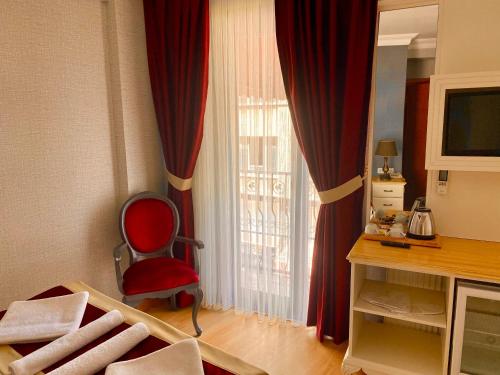 イスタンブールにあるサンタフェ ホテルの窓の前に赤い椅子が備わるお部屋