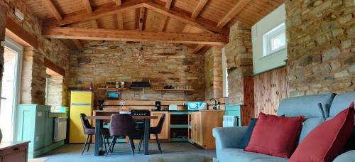 a kitchen and living room with a table and a couch at Galician Rural Accommodation - La Casita in Lugo