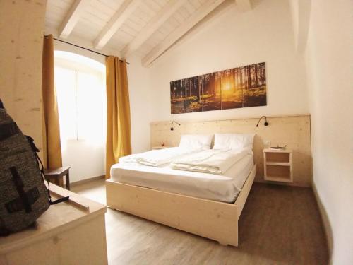 a bedroom with a bed and a painting on the wall at appartamenti Residenza 1928 in Tremosine Sul Garda