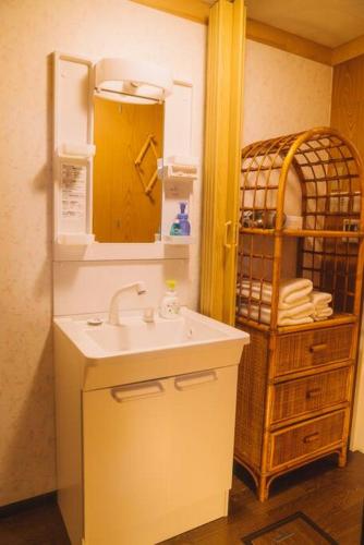a bathroom with a sink and a rack of towels at Kokoro no sato・RYUU in Kyoto