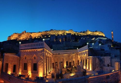 a building with a mountain in the background at Legacy Mesopotamia Hotel in Mardin