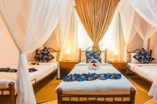 a bedroom with two beds with curtains and a window at Okaseni Lodge in Arusha