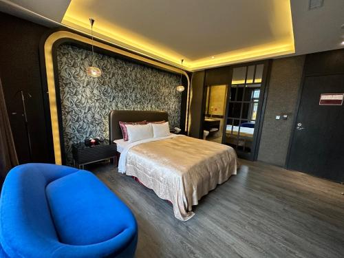 a bedroom with a bed and a blue chair at Song Xia Motel in Dali
