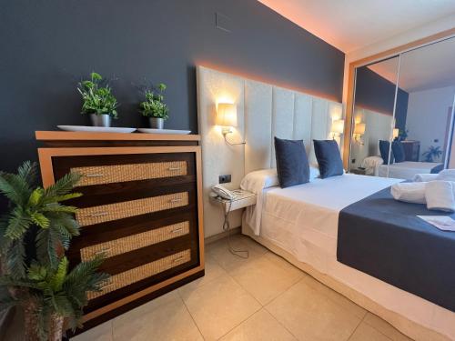 a bedroom with a bed and two potted plants at On Family Islantilla in Islantilla