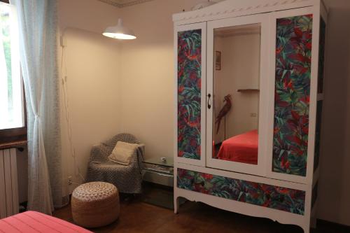 Dormitorio con armario con cama y silla en B&B Casa Elena Room and Apartments with parking, en Gargnano