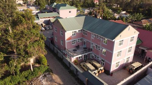 an aerial view of a large house with vehicles parked in front at The Okaseni Lodge in Arusha
