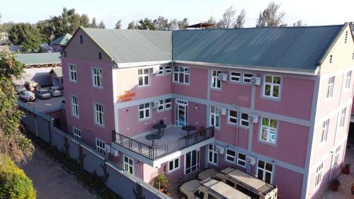 an aerial view of a pink building with a parking lot at The Okaseni Lodge in Arusha