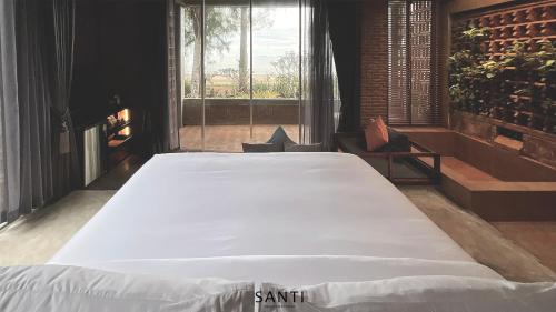 a large bed in a room with a large window at SANTI beach retreat in Ban Rang Pla