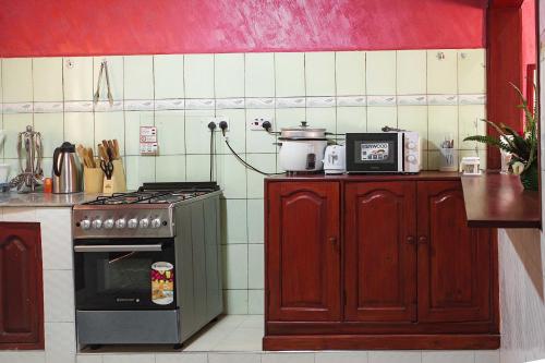 a kitchen with a stove and a microwave in it at The Okaseni Lodge in Arusha