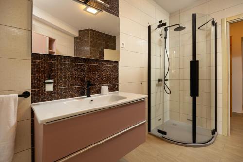 uma casa de banho com um lavatório e um chuveiro em Apartments Lea em Podstrana