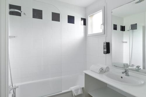 y baño blanco con lavabo y ducha. en Domaine de Saint Orens - Résidence de vacances - Montréal du Gers, en Montréal