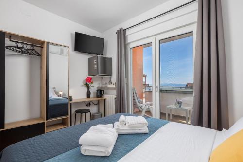 a hotel room with a bed with towels on it at My Way room, parking, sea view, terrace in Rijeka