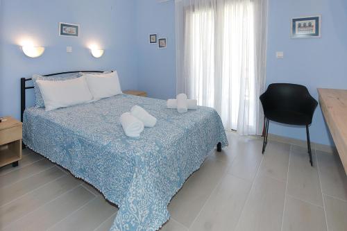 a blue bedroom with a bed and a chair at Agapitos Apartments in Nikiti