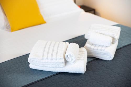 two white towels are sitting on a bed at My Way room, parking, sea view, terrace in Rijeka