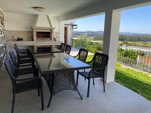 a dining table and chairs on a patio with a view at Casa do Laranjal in Curvos