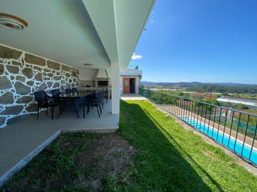 a patio with a table and chairs on a balcony at Casa do Laranjal in Curvos