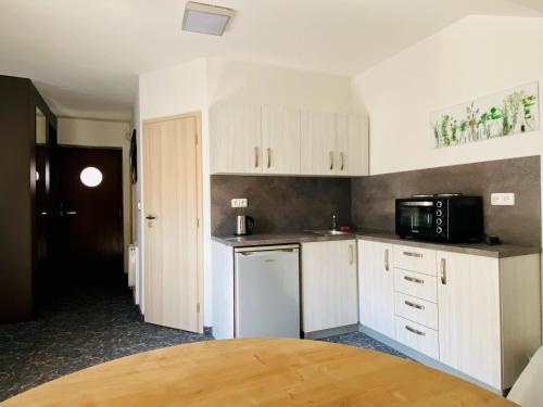 a kitchen with white cabinets and a black microwave at Hotel Mlynska in Uherské Hradiště