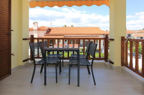 a porch with chairs and a table on a balcony at Agapitos Apartments in Nikiti