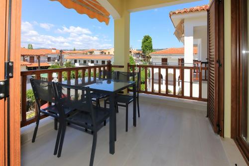 a porch with a table and chairs on a balcony at Agapitos Apartments in Nikiti