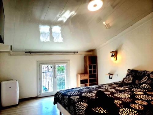 a bedroom with a black and white bed and a window at Charmante maison de village Collioure in Collioure