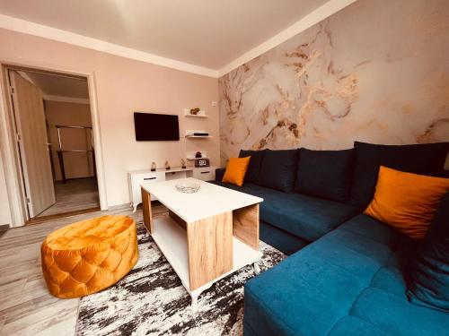 毛茛的住宿－SNAM Rooms&Apartment，客厅配有蓝色的沙发和桌子