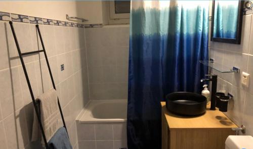 ein Bad mit einer Badewanne, einem Waschbecken und einer Dusche in der Unterkunft Bleu Bambou in Hauterive