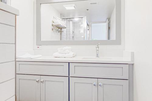 a white bathroom with a sink and a mirror at Century I 1622 in Ocean City