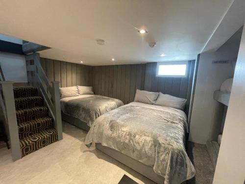 a bedroom with two beds and a staircase at Belvedere Aparthotel - 83 Mount Pleasant in Liverpool