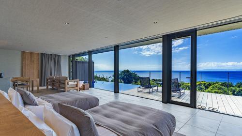 a bedroom with two beds and a view of the ocean at WEAZER 西伊豆 in Izu