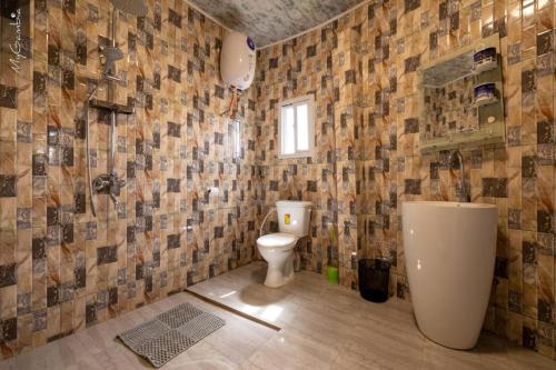 baño con aseo y pared de azulejos en Seaview 1-Bed Suite on Cape Point Beach Bakau en Bakau