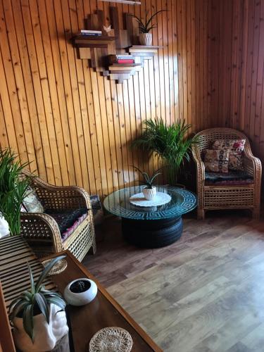 ein Wohnzimmer mit 2 Stühlen und einem Tisch mit in der Unterkunft SEWANS PLACE Homestay in Mirik