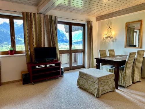- un salon avec une télévision et une table à manger dans l'établissement Haus Wenger Mountain View & Swimming Pool, à Kaprun