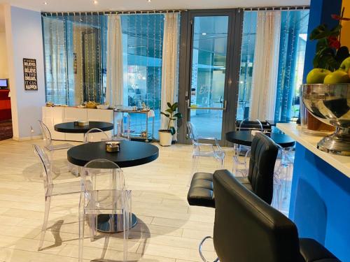 a room with two tables and chairs and windows at Blue Shades Hotel in Pisa