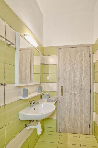 a bathroom with a sink and a mirror and a door at Pavlos Place in Antiparos Town