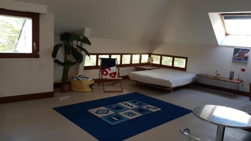 a bedroom with a bed and a blue rug at le dolmen in Séné