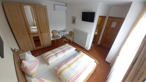 a living room with two beds and a table with chairs at Garni Meinrad in Ora/Auer