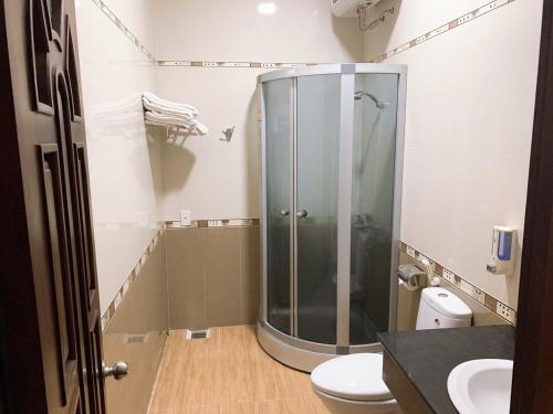 une salle de bain avec douche et toilettes dans l'établissement Gold Rooster Resort, à Phan Rang