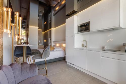 une chambre avec un lit et une cuisine avec des placards blancs dans l'établissement Cosmo Port nature coursives, au Cap d'Agde