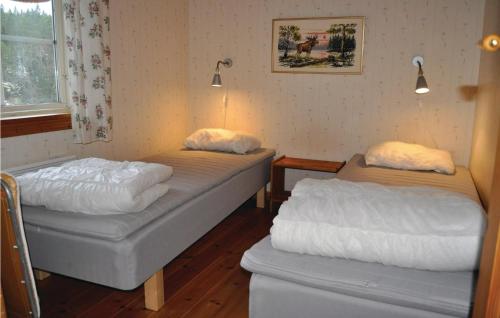 two beds sitting in a room with a window at Amazing Home In Segmon With Sauna in Kangerud