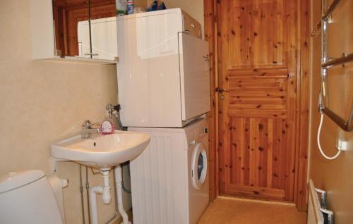 a small bathroom with a white refrigerator and a sink at Amazing Home In Segmon With Sauna in Kangerud