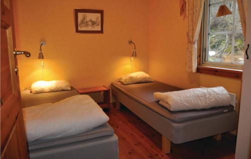 um pequeno quarto com 2 camas e uma janela em Amazing Home In Segmon With Sauna em Kangerud