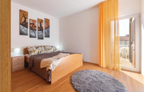 a bedroom with a bed and a window at Stunning Apartment In Rabac With Kitchen in Rabac