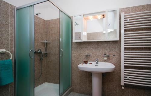 a bathroom with a sink and a glass shower at Stunning Apartment In Rabac With Kitchen in Rabac
