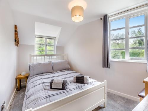 een slaapkamer met een wit bed met 2 kussens erop bij The Tumbling Sailor in Ironbridge